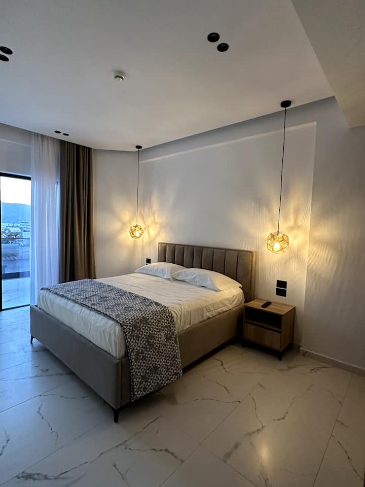Superior Double Room with double bed, pendant lights and balcony doors