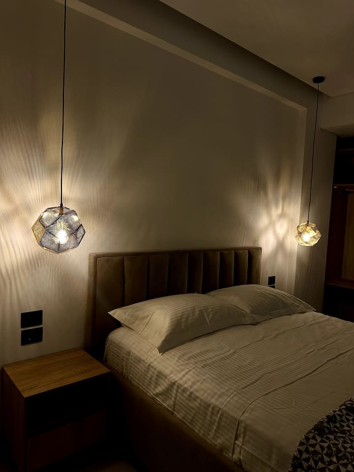 Upholstered headboard and glass pendant lamp in a Superior room